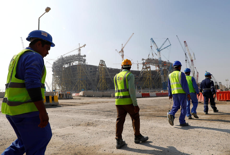 Workers walk towards the construction site of the Lusail stadium which will be build for the upcoming 2022 Fifa soccer World Cup during a stadium tour in Doha, Qatar, December 20, 2019.  REUTERS/Kai Pfaffenbach