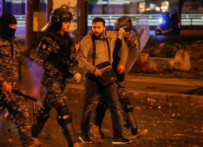 Riot police restrain a protestor during a protest against a ruling elite accused of steering Lebanon towards economic crisis in Beirut