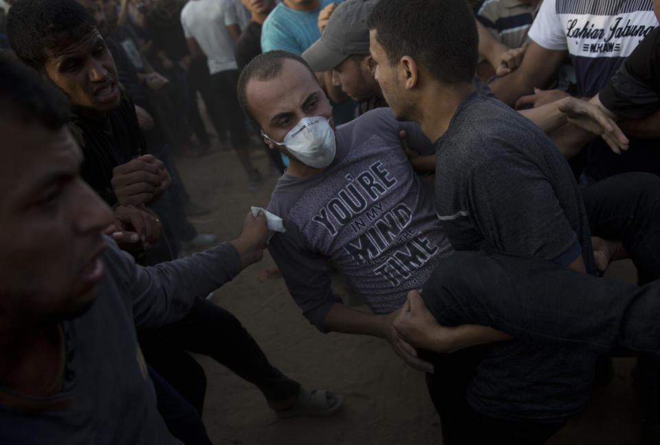 Palestinians carry a wounded protester during a protest at the Gaza Strip's border with Israel, Friday, Oct. 5, 2018. (AP Photo/Khalil Hamra)