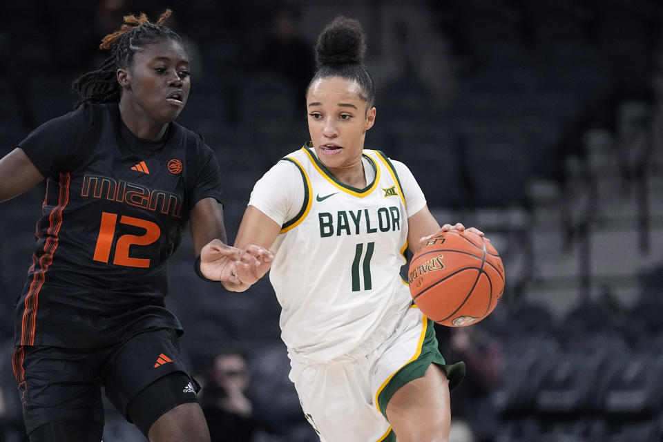 Baylor guard Jada Walker (11) drives around Miami guard Ja'Leah Williams (12) during the second half of an NCAA college basketball game in San Antonio, Saturday, Dec. 16, 2023. (AP Photo/Eric Gay)