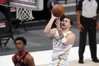 Toronto Raptors' Stanley Johnson (5) looks on as Dallas Mavericks guard Luka Doncic (77) takes a shot in the first half of an NBA basketball game in Dallas, Friday, May 14, 2021. (AP Photo/Tony Gutierrez)