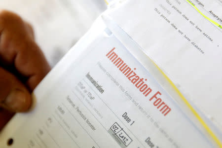 FILE PHOTO: A camper's immunization form and physician's stamp is seen at the Rosmarins Day Camp and Cottages office in Monroe, New York, U.S., May 20, 2019. Picture taken May 20, 2019. REUTERS/Mike Segar