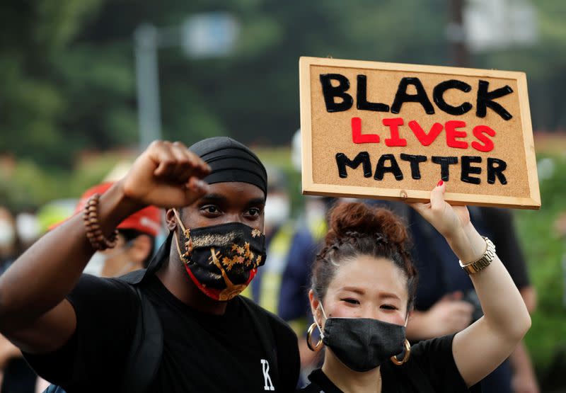 People wearing face masks march during a Black Lives Matter protest following the death in Minneapolis police custody of George Floyd, in Tokyo