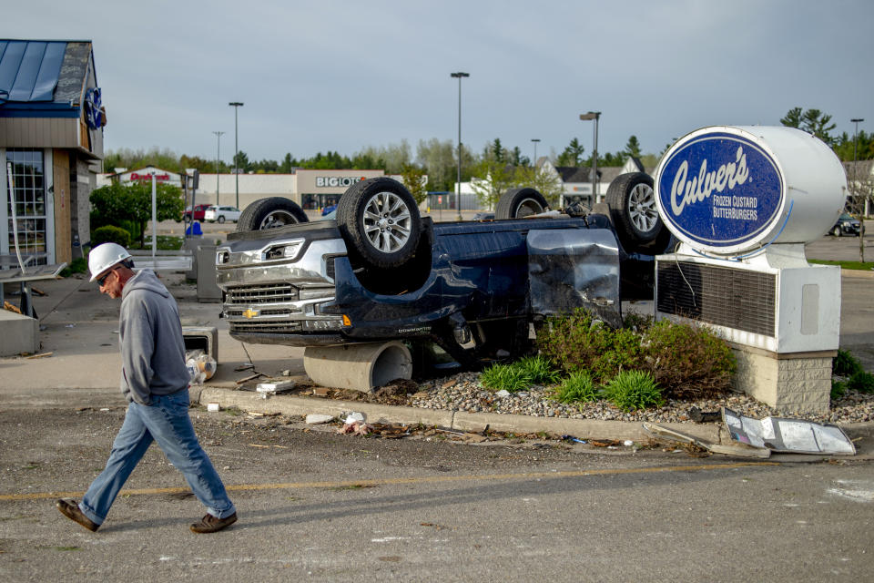 A flipped car sits upside down in the Culver's parking lot amid the damage and aftermath from a tornado along Michigan state Highway 32, Saturday, May 21, 2022, in Gaylord, Mich. (Jake May/MLive.com/The Flint Journal via AP)