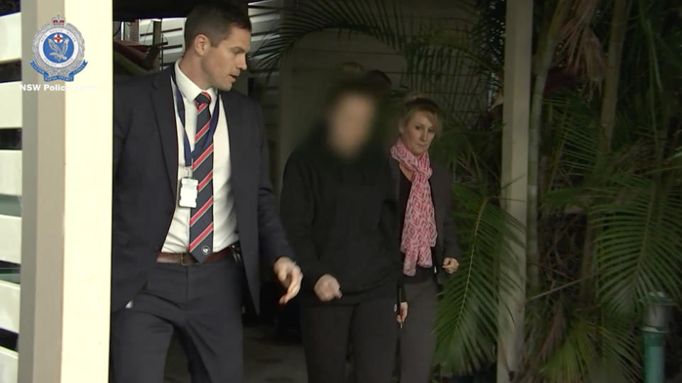 Police vision of a female teacher being taken into custody, accused of sexually assaulting a male student