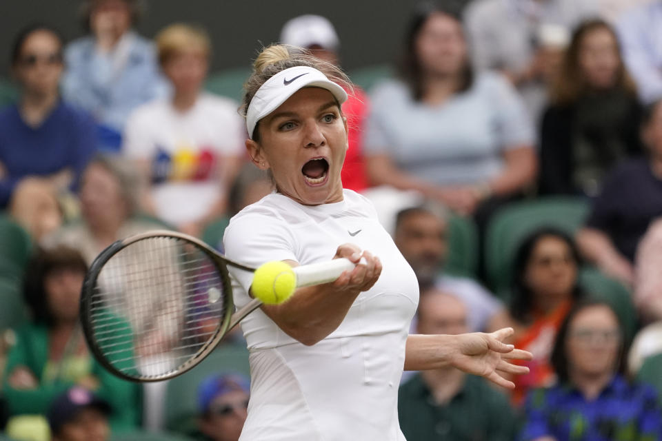 Romania's Simona Halep returns to Spain's Paula Badosa in a women's singles fourth round match on day eight of the Wimbledon tennis championships in London, Monday, July 4, 2022. (AP Photo/Alberto Pezzali)