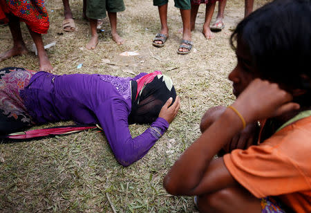 A Rohingya woman cries on the ground, as she received news, over the phone, that her husband was killed by the Myanmar Army, in Cox’s Bazar, Bangladesh August 28, 2017. REUTERS/Mohammad Ponir Hossain