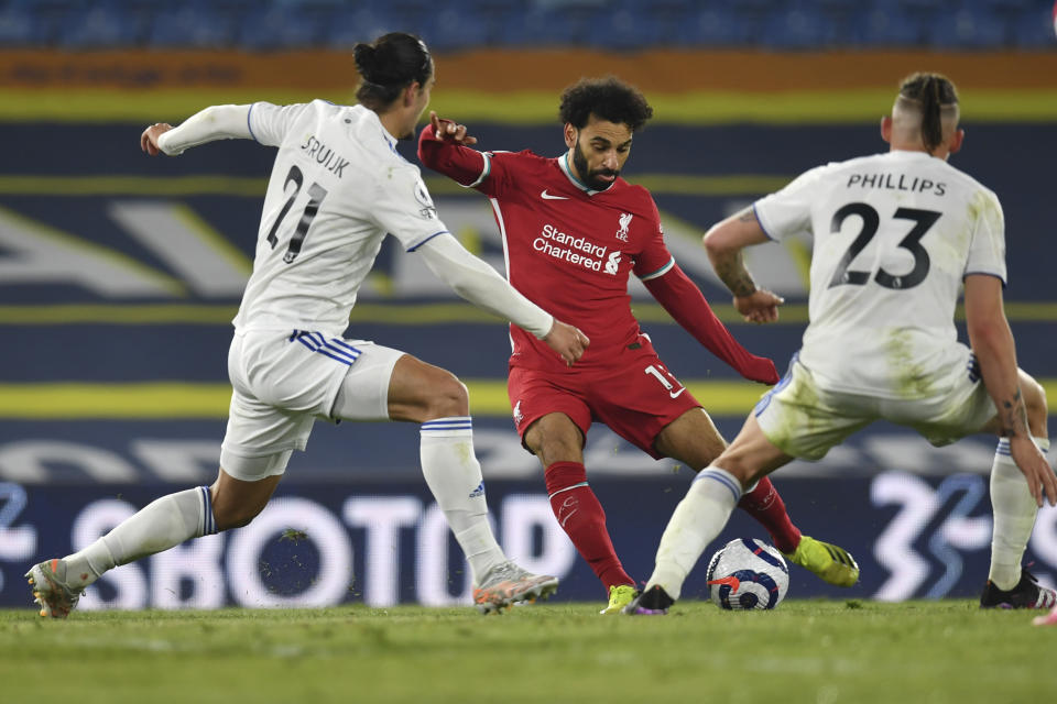 Liverpool's Mohamed Salah, center, is challenged by Leeds United's Pascal Struijk, left and Leeds United's Kalvin Phillips during the English Premier League soccer match between Leeds United and Liverpool at the Elland Road stadium in Leeds, England, Monday, April 19, 2021. (Paul Ellis/Pool via AP)