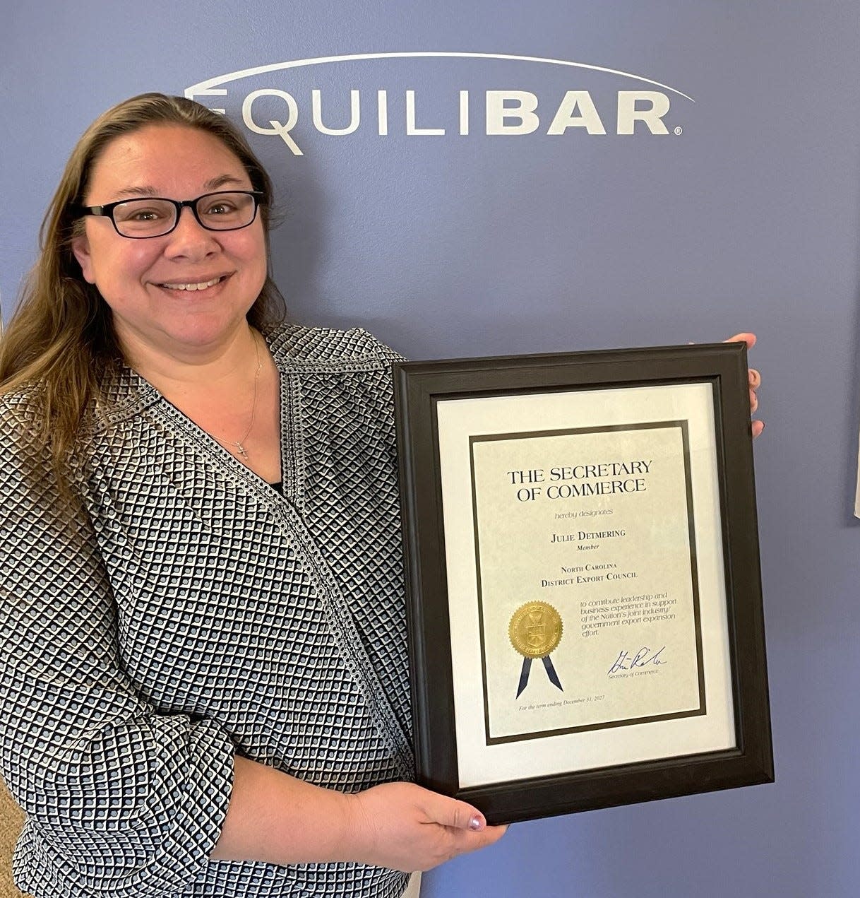 Equilibar's Julie Detmering poses with her certificate from the U.S. Secretary of Commerce.