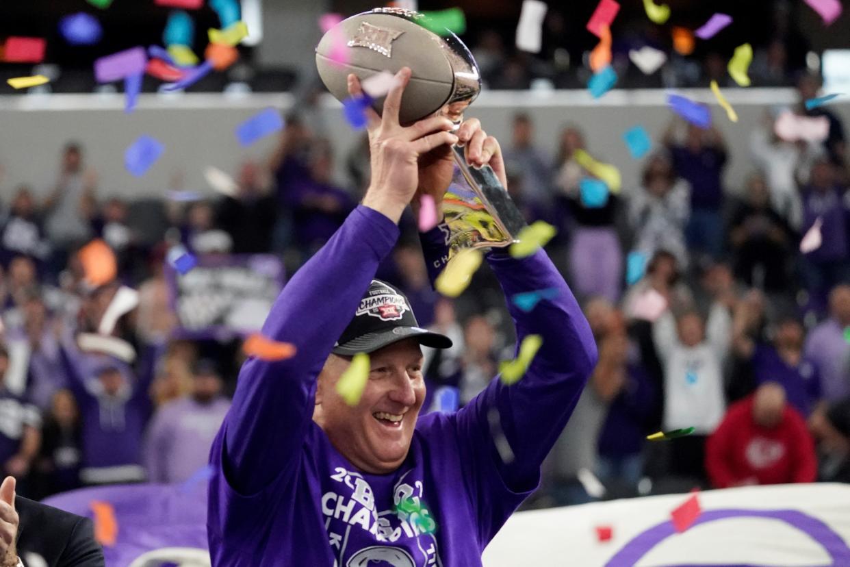 Kansas State coach Chris Klieman hoists the Big 12 championship trophy as confetti falls around him following the Wildcats' 31-28 overtime victory over TCU on Saturday at AT&T Stadium in Arlington, Texas.