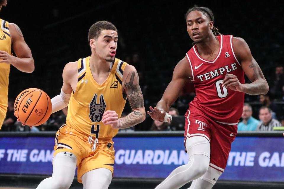 Albany guard Sebastian Thomas (4) drives past Temple guard Quante Berry in a Dec. 10, 2023 game in New York. Thomas is returning to URI next season, after spending last season with the Great Danes.