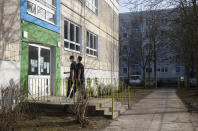 High school students Robin Reyer, left, and Mohammad Alshebli, 16 and 17 years old, enter the Arche, or Ark, an organization that supports children, youth and families, in the Hellersdorf neighbourhood, on the eastern outskirts of Berlin, Germany, Tuesday, Feb. 23, 2021. Since the outbreak of the coronavirus pandemic, the Arche has had to reduce their real face-to-face assistance or traditional classroom schooling as an offer for children, mainly from underprivileged families, drastically. Some kids are still allowed to come over in person, but only once every two weeks. (AP Photo/Markus Schreiber)