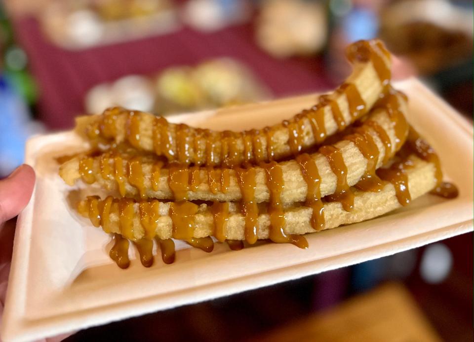 a plate of churros drizzled with caramel