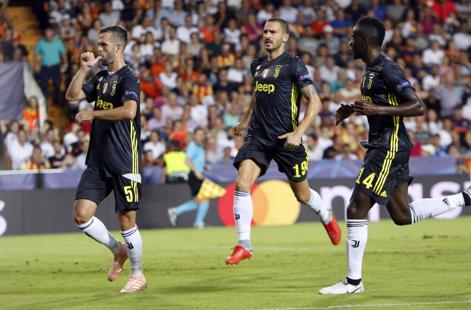 Juventus midfielder Miralem Pjanic, left, celebrates with teammates Leonardo Bonucci and Blaise Matuidi, right, after scoring on a penalty during the Champions League, group H soccer match between Valencia and Juventus, at the Mestalla stadium in Valencia, Spain, Wednesday, Sept. 19, 2018. (AP Photo/Alberto Saiz)