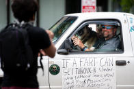 A man smiles from his vehicle while protesting against government closures of non-essential businesses due to the coronavirus on April 24, 2020 in Columbia, South Carolina. Although the state has allowed some non-essential businesses to re-open, restaurants, barber shops, massage therapists, entertainment venues and others remained closed by state order. (Photo by Sean Rayford/Getty Images)