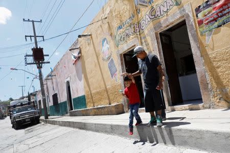 Arturo, 33, a Mexican migrant, who was denied a visa to the United States, leaves an ice cream shop with his son Javen, 6, in Neutla, Guanajuato state, Mexico, April 9, 2019. Picture taken April 9, 2019. REUTERS/Edgard Garrido