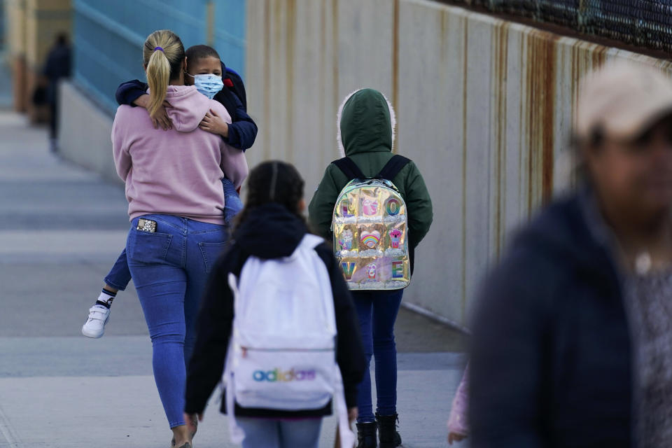 FILE - Children and their caregivers arrive for school in New York, March 7, 2022. U.S. COVID-19 cases are up, leading a smattering of school districts, particularly in the Northeast, to bring back mask mandates and recommendations for the first time since the omicron winter surge ended and as the country approaches 1 million deaths in the pandemic. (AP Photo/Seth Wenig, File)