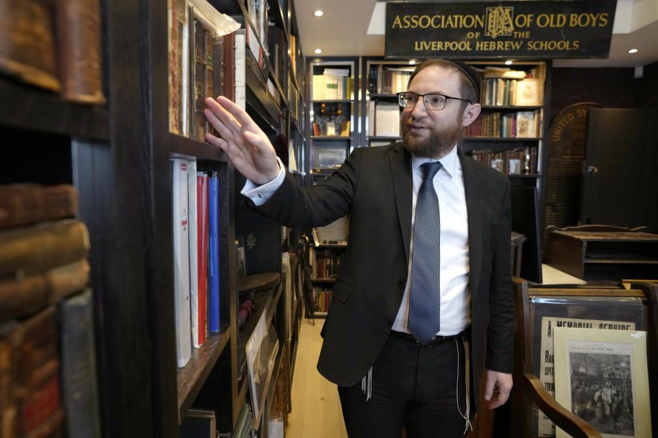 Rabbi Nicky Liss looks through items in a collection belonging to Professor David Latchman of memorabilia related to the history of British Jews, in London, Friday, April 28, 2023. Rabbi Nicky Liss won’t be watching King Charles III’s coronation. He’ll be doing something more important praying for the monarch on the Jewish sabbath. On Saturday, he will join rabbis across Britain in reading a prayer in English and Hebrew that gives thanks for the new king in the name of the “one God who created us all.” (AP Photo/Kirsty Wigglesworth)