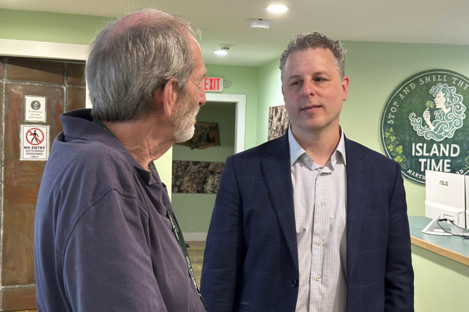 Geoff Rose, left, owner of the Island Time cannabis dispensary, talks with lawyer Adam Fine in Rose's store on June 3, 2024, in Vineyard Haven, Mass. (AP Photo/Nick Perry)