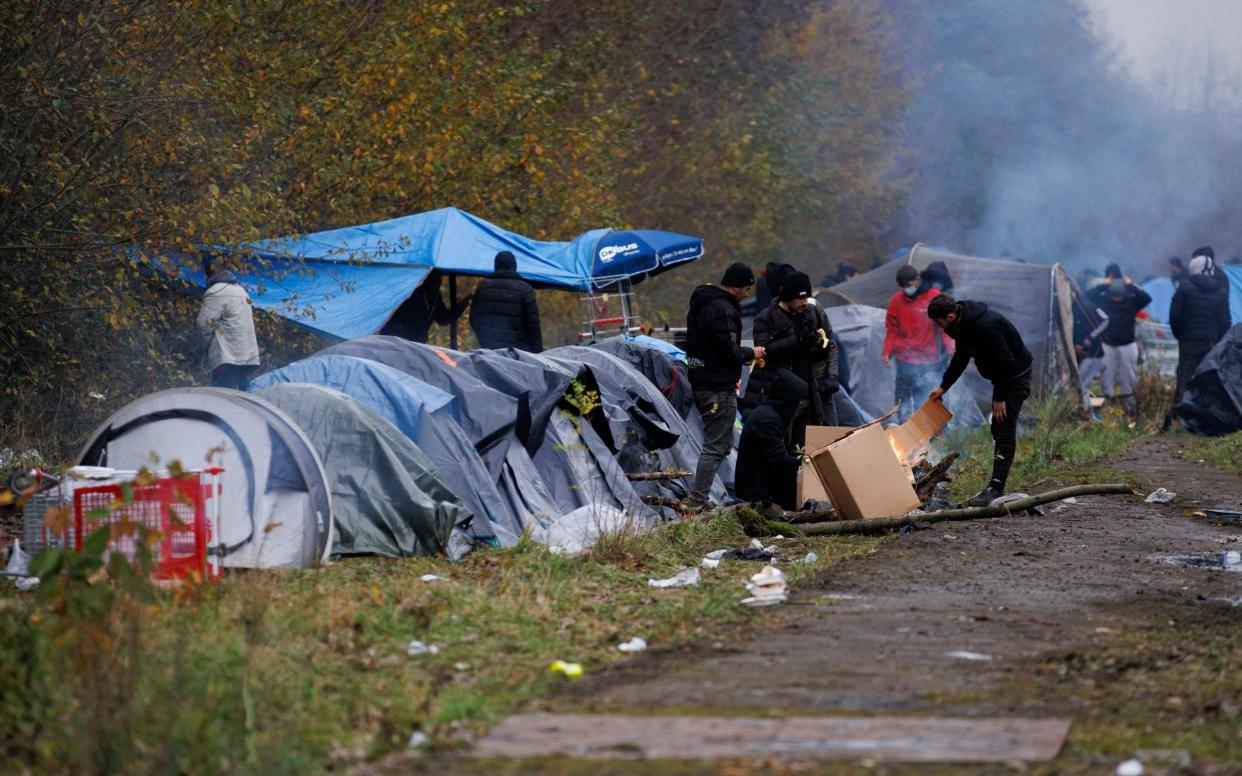 A group of migrants camp on railway lines in Dunkirk following the death of 27 people in the Channel on Wednesday  - Jamie Lorriman