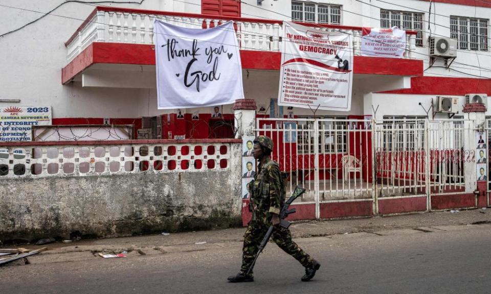 A soldier of the Sierra Leonean Armed Forces walks past APC headquarters in Freetown.