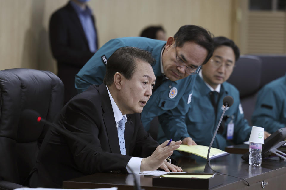 In this photo provided by South Korean Presidential Office, South Korean President Yoon Suk Yeol, left, speaks during the National Security Council (NSC) meeting at the presidential office in Seoul, South Korea, Wednesday, Nov. 2, 2022. Air raid sirens sounded in South Korea after the North fired about a dozen missiles in its direction Wednesday, at least one of them landing near the rivals' tense sea border. (South Korea Presidential Office via AP)