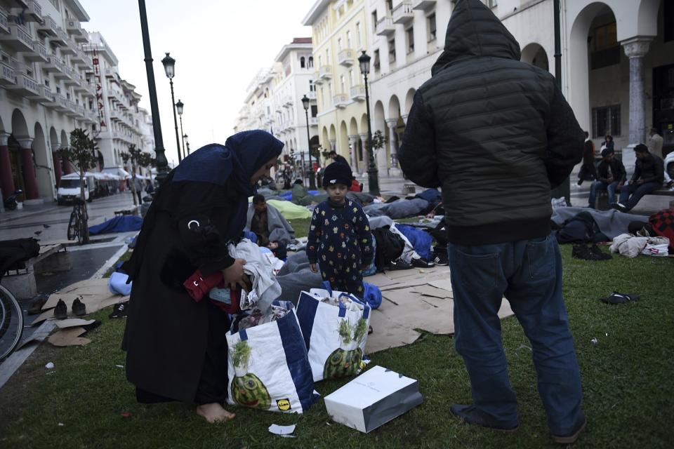 A migrant family pack their belongings as they wait outside a police station in Aristotelous Square at the northern Greek city of Thessaloniki, Monday, Oct. 8, 2018. Dozens of refugees and migrants have gathered outside a police station in Greece's second largest city, waiting for hours to be formally arrested and gain temporary residence in the European Union country. (AP Photo/Giannis Papanikos)