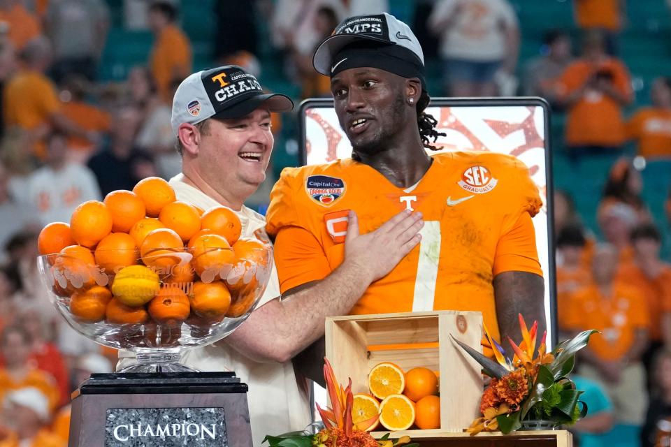 Tennessee coach Josh Heupel, left, and quarterback Joe Milton III (7) stand behind the trophy after the team's win over Clemson in the Orange Bowl NCAA college football game Saturday, Dec. 31, 2022, in Miami Gardens, Fla. (AP Photo/Lynne Sladky