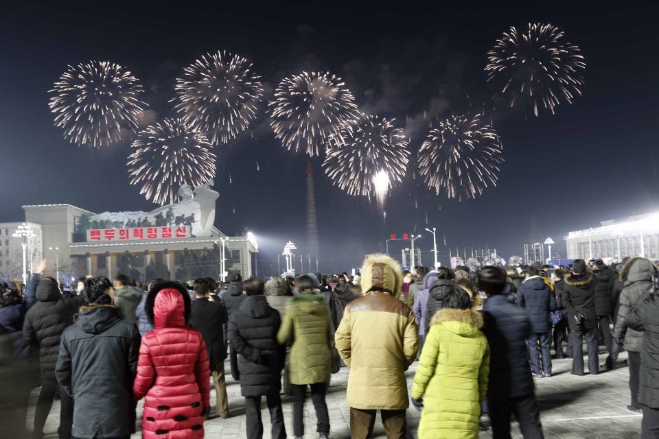 A fireworks display decorates the night sky to celebrate the New Year, as crowds of people look on, at Kim Il Sung Square in Pyongyang, North Korea, early Friday, Jan., 1, 2021. (AP Photo/Jon Chol Jin)
