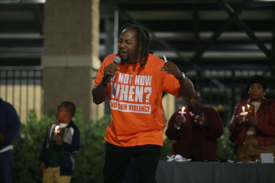 Todd Rhodes, Jr, president and founder of the Savannah Royal Lions youth football team, leads a prayer during a Stop Gun Violence candlelight vigil on Tuesday evening outside Memorial Stadium.