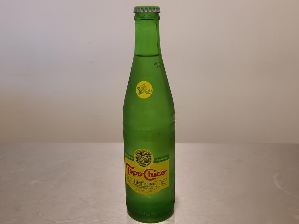 bottle of lime topo chico sparkling mineral water on a kitchen counter