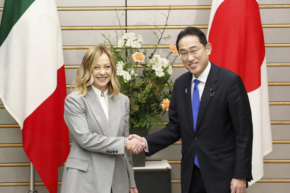 Italian Premier Giorgia Meloni, left, shakes hands with Japanese Prime Minister Fumio Kishida as they pose for a photo before their meeting at the prime minister's office in Tokyo on Monday, Feb. 5, 2024. (Rodrigo Reyes Marin/Pool Photo via AP)