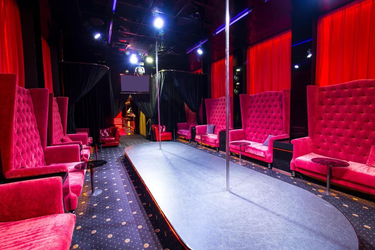 interior strip club with sofas and tables poles