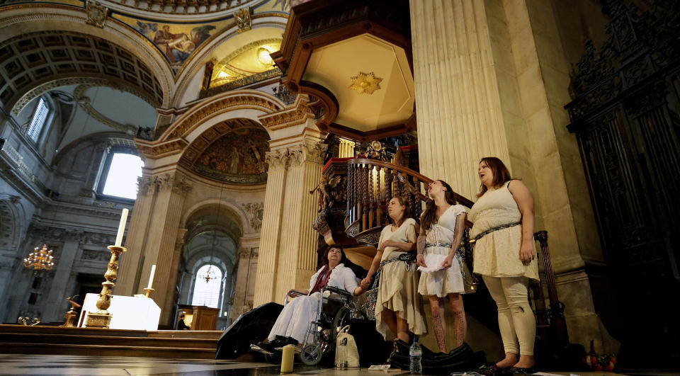 Four women activists of the Occupy movement protest chained to the pulpit inside St Paul's Cathedral as preparations for evensong take place in London, Sunday, Oct. 14, 2012. Several supporters of the anti-corporate Occupy movement chained themselves to the pulpit of St. Paul's Cathedral during a service on Sunday in an action marking the anniversary of its now-dismantled protest camp outside the London landmark. (AP Photo/Alastair Grant)
