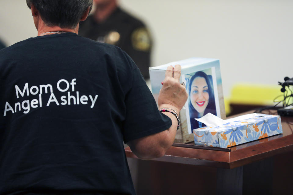 Kristine Young, mother of Ashley Young, gestures to a box containing her daughter's ashes during the sentencing of Jared Chance in Kent County Circuit Court, Thursday, Oct. 10, 2019, in Grand Rapids, Mich. Chance, a Michigan man convicted of killing and dismembering Ashley Young has been sentenced to at least 100 years in prison after a judge called his actions "reprehensible and heinous."(Brian Hayes/The Grand Rapids Press via AP)