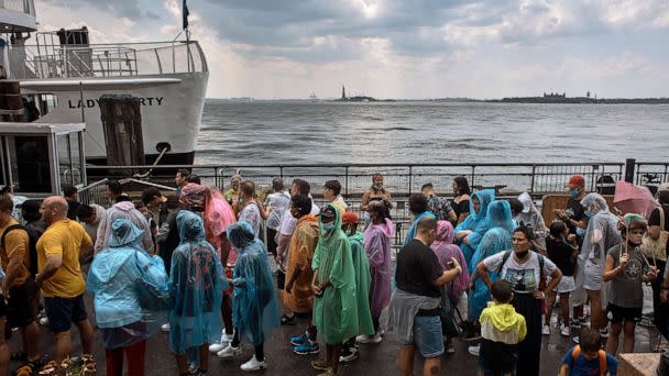 PHOTO: People wait to take a boat under the rain during a summer heat wave, Thursday, July 21, 2022, in New York. (Andres Kudacki/AP)
