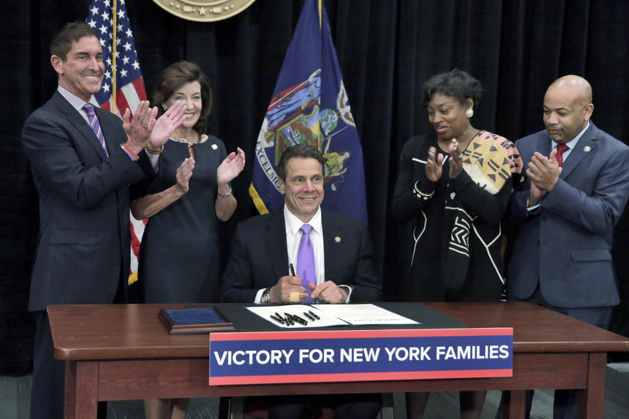 New York Gov. Andrew Cuomo (C) is applauded after he signed  a law that will gradually raise New York's minimum wage to $15, at the Javits Convention Center, in New York,  April 4, 2016. Standing, left to right, are New York state Sen. Jeffrey Klein, New York Lt. Gov. Kathy Hochul, New York state Sen. Andrea Stewart-Cousins, and New York state Assembly Speaker Carl Heastie. REUTERS/Richard Drew/Pool