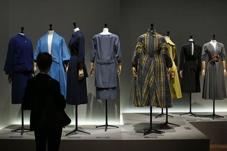 A visitor looks at vintage dresses by designers Marcel Rochas, Schiaparelli, Jeanne Lafaurie, Balenciaga, Gres, Madeleine Vramant, Jacques Fath and Pauline Trigere presented in the exhibition "Les Annees 50, La mode en France" (The 50s. Fashion in France, 1947-1957) at the Palais Galliera fashion museum in Paris, July 10, 2014. REUTERS/Benoit Tessier