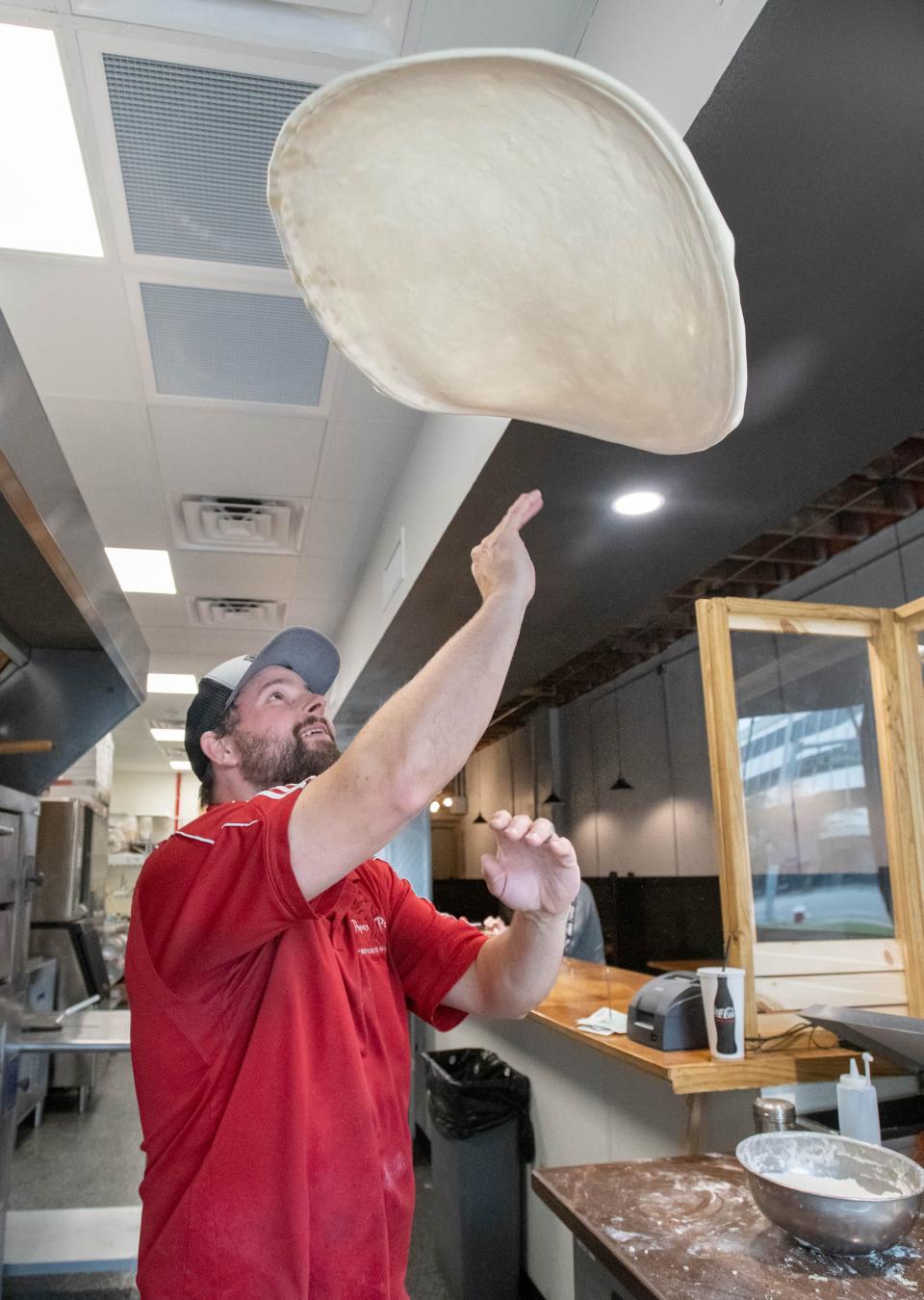 Owner Nick Burleigh tosses dough Tuesday as he prepares a pizza at the new Papa's Pizza location on Garden Street in downtown Pensacola.