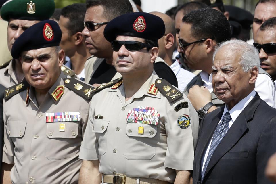 FILE - In this Friday, Sept. 20, 2013 file photo, Egypt's Defense Minister Gen. Abdel-Fattah el-Sissi, center, Egyptian Prime Minister Hazem el-Beblawi, right, and army's Chief of Staff Lt. Gen. Sedki Sobhi, left, attend the funeral of Giza Police Gen. Nabil Farrag in Cairo, Egypt. Egypt's military chief is looking for a strong turnout in next week's nationwide constitutional referendum as a mandate on whether he should run for president, senior officials tell the AP. The popular general who ousted President Mohammed Morsi and ordered a crackdown on the Muslim Brotherhood could be disappointed as his Islamist foes have promised a boycott and mass demonstrations raising fears of violence that are likely to keep voters at home. (AP Photo/Hassan Ammar, File)