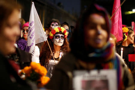 Activists with faces painted to look like the popular Mexican figure "Catrina" take part in a march against femicide during the Day of the Dead in Mexico City, Mexico, November 1, 2017. REUTERS/Carlos Jasso