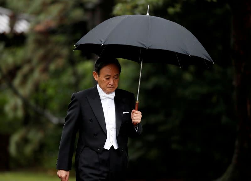 FILE PHOTO: Japan's Chief Cabinet Secretary Yoshihide Suga arrives at the ceremony site where Emperor Naruhito will report the conduct of the enthronement ceremony at the Imperial Sanctuary inside the Imperial Palace in Tokyo