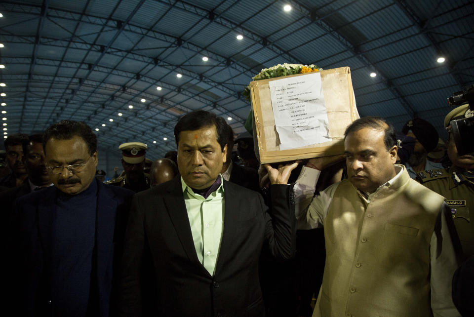 Assam state Chief minister Sarbananda Sonowal, center, helps carry the coffin containing the remains of Central Reserve Police Force (CRPF) soldier Maneswar Basumatary, who was killed in Thursday bombing in Kashmir, at the air force station in Gauhati, India, Saturday, Feb. 16, 2019. India's prime minister warned of a "crushing response" to the suicide bombing of a paramilitary convoy in Indian-controlled Kashmir that killed at least 40 and was the deadliest in the divided region's volatile history. (AP Photo/Anupam Nath)