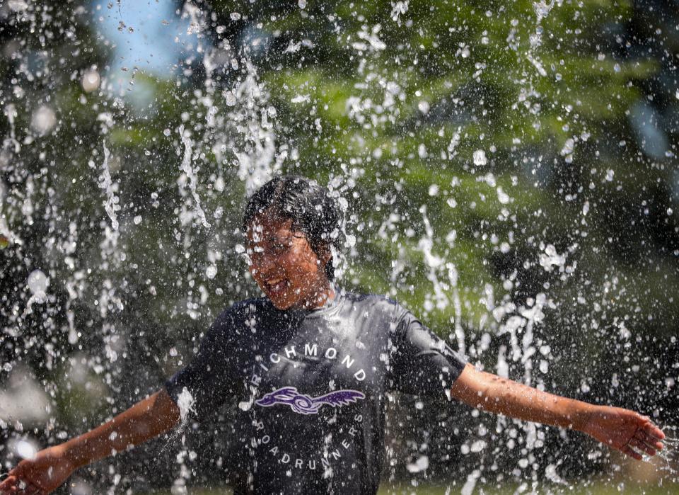 Delaylah Nunez, 10, cools off from the heat in a splash pad in June 2021 at River Road Park.