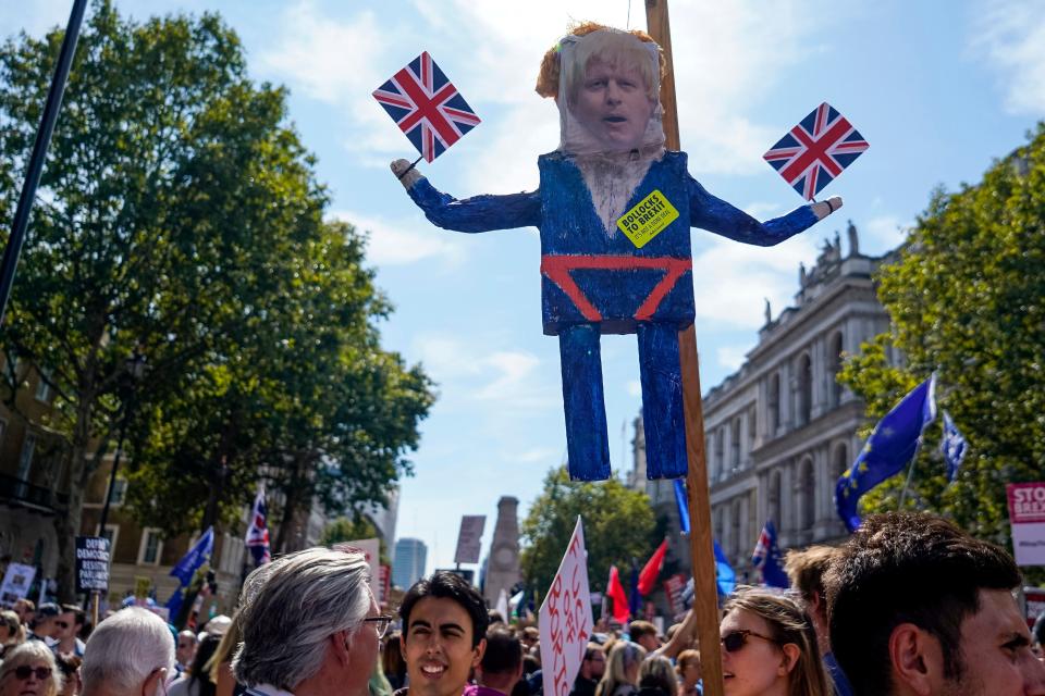 Demonstrators carry an effigy of Britain's Prime Minister Boris Johnson at a protest against the move to suspend parliament in the final weeks before Brexit outside Downing Street in London on August 31, 2019. - Demonstrations, being dubbed "Stop The Coup" by organisers, were to be held across Britain on August 31 against Prime Minister Boris Johnson's move to suspend parliament in the final weeks before Brexit. The protests come ahead of an intense political week in which Johnson's opponents will seek to block the move in court and legislate against a no-deal departure from the European Union. (Photo by Niklas HALLE'N / AFP)        (Photo credit should read NIKLAS HALLE'N/AFP/Getty Images)