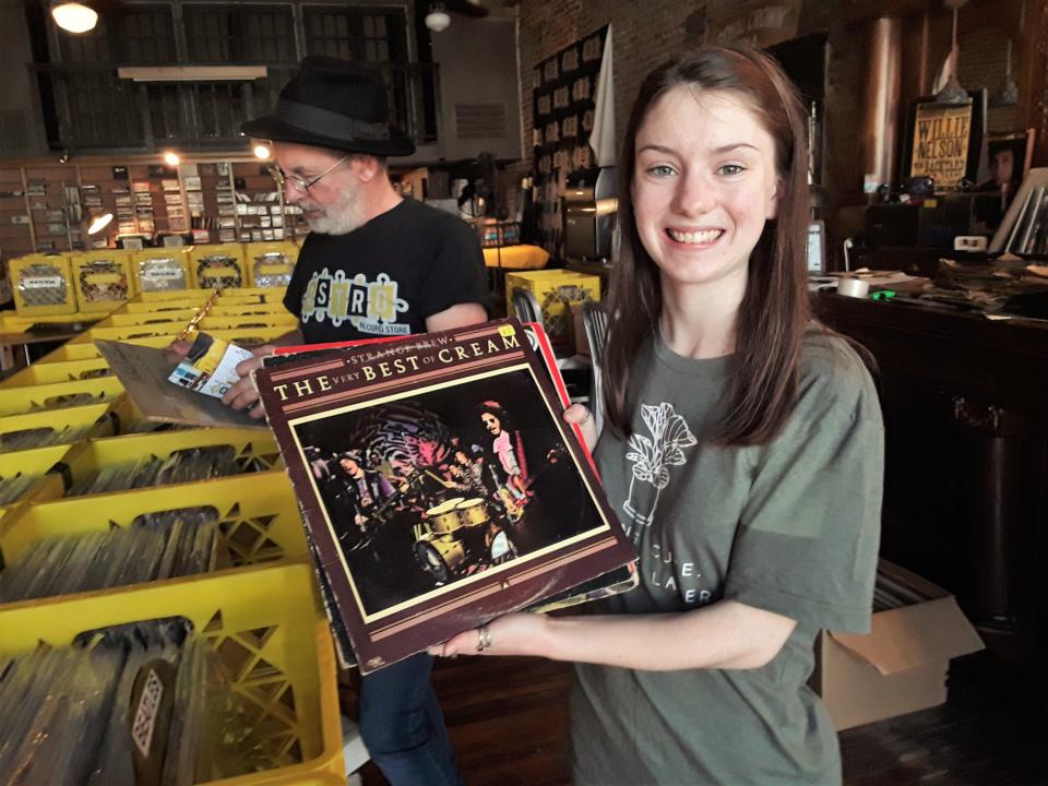 Haley Redd of Bastrop shows off “The Very Best of Cream” album she bought at Astro Record Store. Redd says store owner Kevin "Lippy" Mawby, in background, "is a really cool guy and knowledgeable about music."