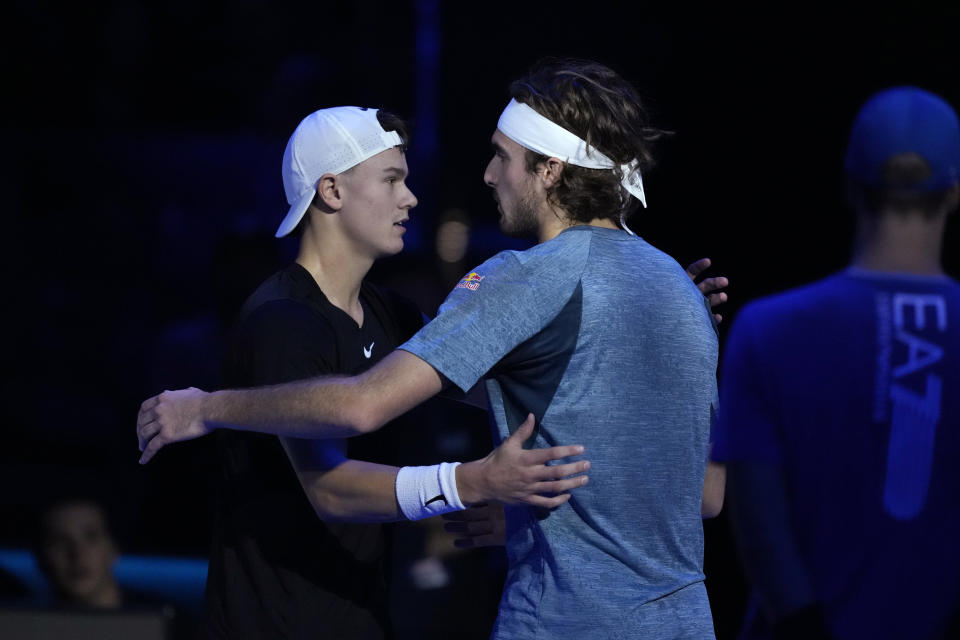 Greece's Stefanos Tsitsipas, right, embraces Denmark's Holger Rune after injuring during the singles tennis match of the ATP World Tour Finals at the Pala Alpitour, in Turin, Italy, Tuesday, Nov. 14, 2023. (AP Photo/Antonio Calanni)