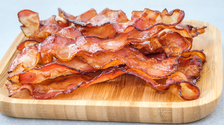 Bacon strips on wooden board 