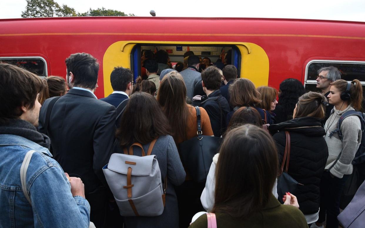 Passengers try to board a South Western Railway train during an earlier strike  - PA