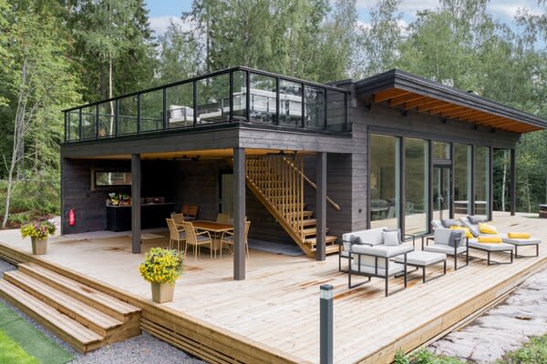This prefab also has a wraparound deck with a shaded dining area.